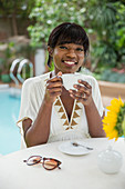 Woman drinking coffee at poolside