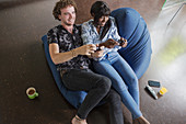Happy couple playing video game on beanbag chair