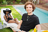 Portrait happy man with digital tablet at poolside