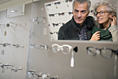 Senior couple shopping for eyeglasses in optometry shop