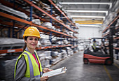 Confident female worker with clipboard in warehouse