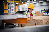 Female worker using laptop in factory