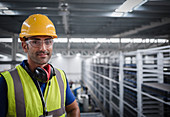 Portrait male worker with ear protectors in factory