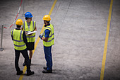 Supervisor and workers with clipboard talking in factory