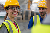 Smiling female worker talking with coworkers in factory