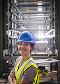 Portrait smiling, confident female worker in steel factory