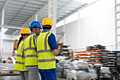 Supervisor and workers walking and talking in warehouse