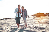 Young couple walking on sunny summer beach