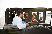 Young couple smiling in back seat of jeep