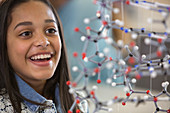 Curious, smiling girl student examining molecular structure