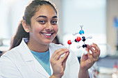 Girl student holding molecular model in classroom