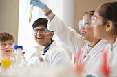 Students examining liquid in test tube in classroom