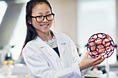 Girl student holding molecular structure in classroom