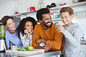 Multi-ethnic family making healthy green smoothie