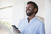 Laughing man using cell phone