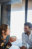 Multi-ethnic couple drinking coffee and talking