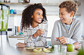 Smiling brother and sister drinking healthy green smoothie