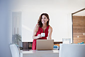 Woman drinking coffee and working at laptop