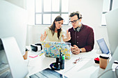 Designers brainstorming, gesturing at laptop in office