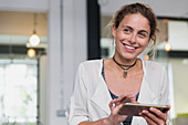 Portrait smiling businesswoman using digital tablet