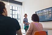 Female architect at television screen leading meeting