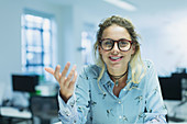 Smiling, confident, gesturing businesswoman in office