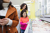 Mother and daughter shopping frozen food in supermarket