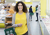 Portrait smiling, confident woman shopping in supermarket