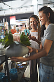 Women using camera phone in home decor shop