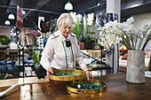 Senior woman looking at trays in home decor shop