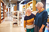 Happy laughing senior women friends in home goods store