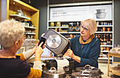 Senior women with smart phone shopping in home goods store