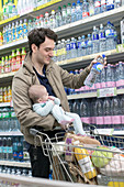 Father with baby daughter grocery shopping in supermarket