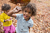 Portrait playful boy holding autumn leaf