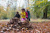 Family playing in autumn leaves in woods