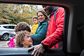 Happy multiethnic family outside car