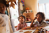 Brothers and sister making autumn crafts at table