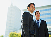 Smiling businessmen in front of highrise