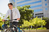 Smiling businessman with bicycle outdoors