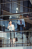 Smiling businesswoman using cell phone at window
