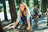 Smiling woman bike riding in woods