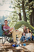 Smiling family at campsite in woods