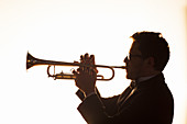 Silhouette of trumpeter performing
