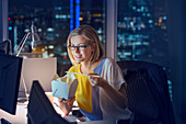 Businesswoman eating take out food at desk in office
