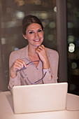 Portrait of confident businesswoman working at laptop
