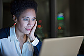 Focused businesswoman working late at laptop