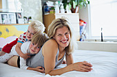 Portrait of mother with sons in bed