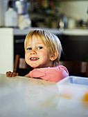 Smiling boy leaning against kitchen counter