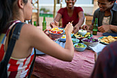 Young friends eating tacos at patio table