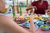 Young woman eating lunch at patio table